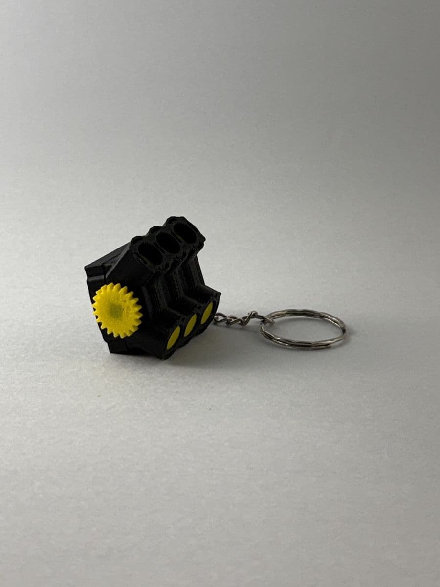 Chaveiro motor V6 preto com volante amarelo